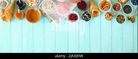 Sommerliches Eisbuffet mit verschiedenen Geschmacksrichtungen und süßen Belägen. Oben Tischszene auf blauem Holzhintergrund. Stockfoto