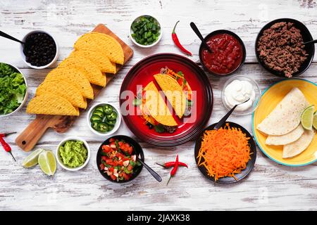 Taco Bar Tisch Szene mit einer Vielzahl von Zutaten. Blick von oben auf einem rustikalen weißen Holzhintergrund. Mexikanisches Buffet. Stockfoto