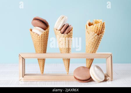 Verschiedene Makronen-Plätzchen in Eiszapfen. Auf blauem Hintergrund Stockfoto