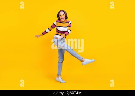 In voller Größe Foto von lustigen weißen Frisur ältere Dame Tanz tragen Brillen Pullover Jeans Sneakers isoliert auf gelbem Hintergrund Stockfoto