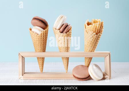 Verschiedene Makronen-Plätzchen in Eiszapfen. Auf blauem Hintergrund Stockfoto