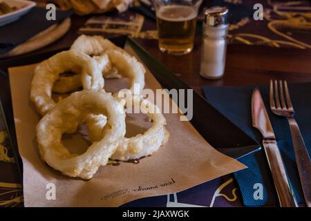 Nahaufnahme der Zwiebelringe im Teig Stockfoto