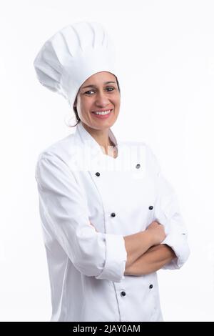 Fröhliche junge Latine Frau Koch Koch lächelt an der Kamera mit Koch Outfit isoliert auf weißem Hintergrund. Vertikales Format. Stockfoto