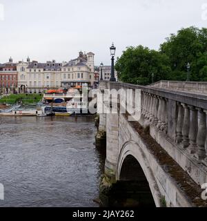 Richmond, Greater London, England, Mai 18 2022: Brücke über die Themse mit Richmond-Stadt, inklusive einem Bootshaus im Hintergrund auf dem Fluss Stockfoto