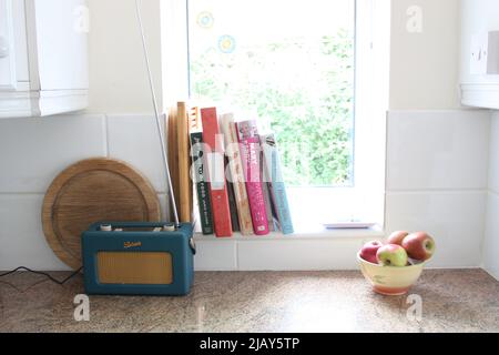 Küche Stillleben von Kochbüchern auf einem Fensterbrett und einem modernen Retro Roberts Radio Stockfoto