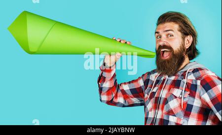 Glücklicher bärtiger Mann mit Lautsprecher aus Papier. Saisonangebot. Männlich mit Megaphon. Werbekonzept Stockfoto