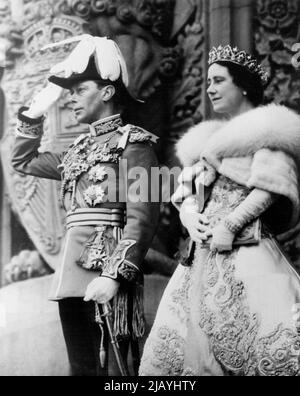 Royal Salute in Ottawa -- König George VI. Hebt seine Hand in Royal, Salute on the Steps of Parliament Building, Ottawa, Mai 19.. Neben dem König, der in der Uniform eines Feldmarschalls der britischen Armee gekleidet ist, steht Königin Elizabeth, die eine diamantene Tiara und einen kurzen Umhang aus blauen Fuchsfellen trägt. 20.Mai 1939. (Foto von ACME). Stockfoto