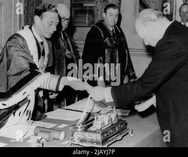 König überreicht Churchill den Preis -- König George VI (links) überreicht dem ehemaligen Premierminister Winston Churchill die "Freedom of the Worshipful Company of Ship-Wrights" bei einer Sitzung des Gerichts des Unternehmens im Mansion House, London, am 24. Oktober. Andere auf dem Foto sind nicht identifiziert. 31. Oktober 1945. (Foto von Associated Press Photo). Stockfoto