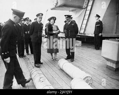 Königlicher Besuch des berühmten britischen Schlachtschiffs - der König und die Königin mit dem Kommandanten des Königs George V - Kapitän T. E. Halsey, D.S.O., R.N., und beobachtete, wie 14-Zoll-Kordit-Ladungen über das Deck gerollt wurden. Aufgenommen an einer Nordbasis, als der König und die Königin in Begleitung von Prinzessin Elizabeth und Prinzessin Margaret das britische Schlachtschiff König George V zum Abschied besuchten, bevor sie sich der britischen Ostindien-Flotte anschloss. Es wird nun enthüllt, dass der König Georg V. an Tie-großen Luft-See-Operationen gegen japanische Öllieferungen in Sumatra teilgenommen hat. 16. April 1945. (Foto von PNA). Stockfoto