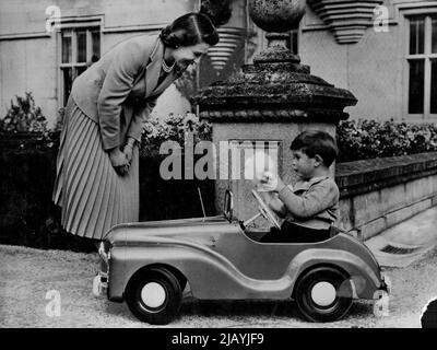 Prinz Charles ist heute vier : Diese entzückende Mutter-Kind-Studie zeigt der Königin, wie sie Prinz Charles mit einer Handpuppe in seinem Spielzeugauto auf dem Gelände von Balmoral Castle spielt. Sie wurde speziell zum Gedenken an den vierten Geburtstag von Prinz Charles am 14. November angefertigt. Das ist das Tretauto, das Prinz Charles' größte Freude ist. Das Auto ist nicht aufwendig, sondern hat Lichter und einen Dummy-Funkmast. 24. Dezember 1952. (Foto von Associated Press Photo). Stockfoto