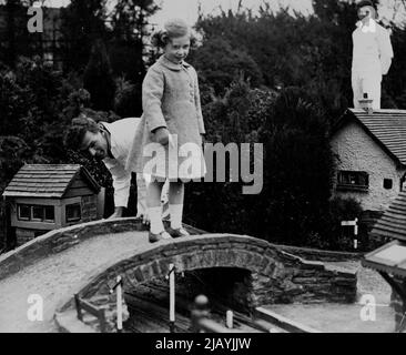 Kleine Prinzessinnen besuchen das Modelldorf -- Prinzessin Margaret Rose steht auf einer Brücke, die die Eisenbahn im Modelldorf überspannt. Prinzessin Elizabeth und Prinzessin Margaret Rose besuchten heute das Modelldorf und die Gärten von Bekonscot in Beaconsfield, Buckinghamshire. Sie wurden von ihren Eltern (dem Herzog und der Herzogin von York) und Königin Mary begleitet. 15. April 1936. (Foto von Topical Press). Stockfoto