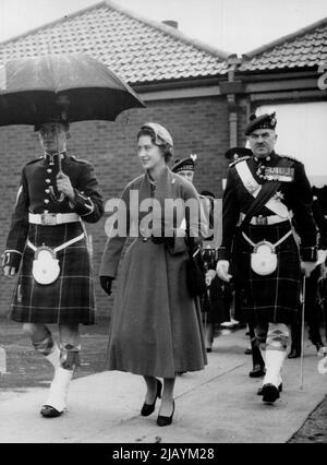 Prinzessin präsentiert neue Farben - die Prinzessin, Oberst-in-Chief, wird von einem Regenschirm vor dem Regen geschützt, während sie mit dem Oberst, Generalmajor R.E., geht Urquhart, während der Zeremonien. Prinzessin Margaret hat heute am 19. Oktober dem 1. Bataillon der Highland Light Infantry im Bulford Camp, Wiltshire, neue Farben vorgestellt. 28. Oktober 1955. (Foto von Associated Press Photo). Stockfoto