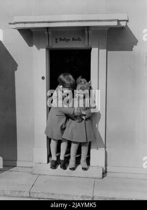 Auf den Stufen des Little Welsh House, ihres eigenen Miniaturhauses, stehen Prinz Charles und Prinz Anne zusammen, tief beschäftigt mit einem neuen Teddybären. 18. Oktober 1954. (Foto von Lisa). Stockfoto