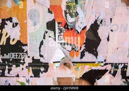 Zerrissene abblätternde Poster an der Wand Stockfoto