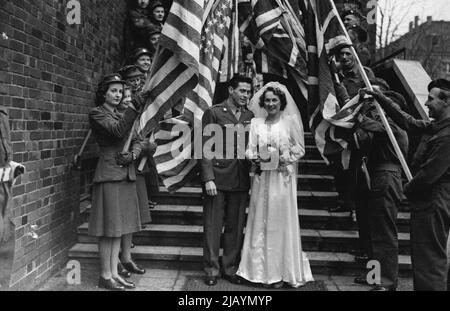 Anglo American Wedding in Berlin -- Diese hübsche Braut ist ATS Private Joyce Wiltshire von Grand Parade, Harringay, London, verheiratet in Berlin mit James Kerrigan aus New Haven Connecticut, USA. Das Paar traf sich vor 2 Jahren in London, als sie beide bei SHAEF arbeiteten, und die Romanze wurde später in Berlin erneuert. Das Brautpaar am R.C. Kirche des Heiligen Geistes, Charlottenberg, Berlin. 24. Dezember 1945. (Photo by Mirror Features). Stockfoto