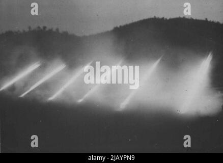 Eine American Field Battery sendet eine wüstende Explosion von 4,5 Raketen über die Köpfe australischer Infanteristen auf die koreanische schlachtfront, die kommunistische Krisenherde zerstört. 22.Mai 1953. (Foto von British Commonwealth Public Relations). Stockfoto