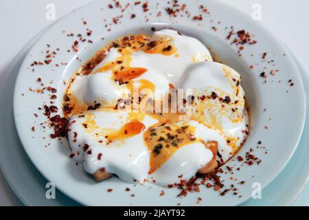 Türkische traditionelle Küche 'Manti' (türkische Ravioli) mit Joghurt auf dem Teller. Stockfoto