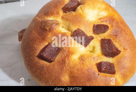 Süßes Brot mit Guava-Marmelade und süßem Mehl auf einem braunen Holztisch. Es ist eine in Brasilien und Portugal verbreitete Art von Brot, die aus süßem Teig hergestellt wird. Stockfoto