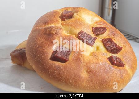 Süßes Brot mit Guava-Marmelade und süßem Mehl auf einem braunen Holztisch. Es ist eine in Brasilien und Portugal verbreitete Art von Brot, die aus süßem Teig hergestellt wird. Stockfoto