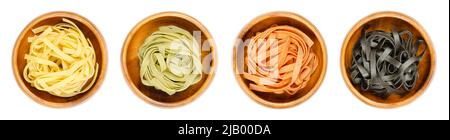 Tagliatelle Pasta, in vier verschiedenen Farben, zu Nestern verdreht, in Holzschalen. Ungekochte und getrocknete traditionelle italienische Eiernudeln. Stockfoto