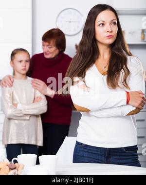 Junge Frau, die mit der kleinen Tochter und Mutter in Konflikt steht Stockfoto