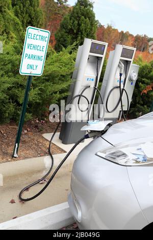 Parkplatz mit einem Elektrofahrzeug, das die Batterie lädt Stockfoto