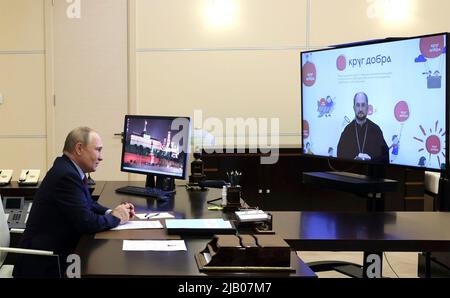 Moskau, Russland. 01.. Juni 2022. Der russische Präsident Wladimir Putin hält eine Videokonferenz mit Erzpriester Alexander Tkachenko, dem Leiter der Circle of Freundlichkeit Foundation, aus der Präsidentenresidenz in Novo-Ogaryovo, am 1. Juni 2022 außerhalb von Moskau, Russland, ab. Quelle: Mikhail Metzel/Kremlin Pool/Alamy Live News Stockfoto