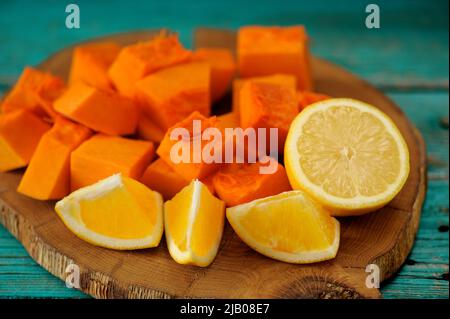 Süßer Kürbis, Orange und Zitrone auf Holzbrett in Nahaufnahme geschnitten Stockfoto