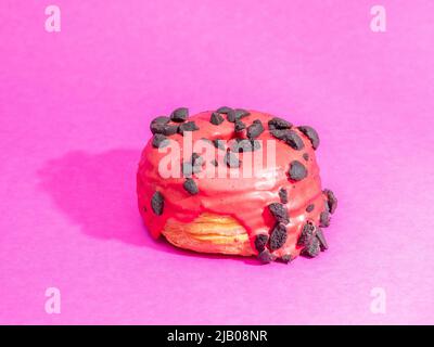 Rote Kronuts auf einem rosa Hintergrund. Hochwertige Fotos Stockfoto