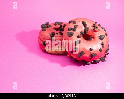 Rote Kronuts auf einem rosa Hintergrund. Hochwertige Fotos Stockfoto