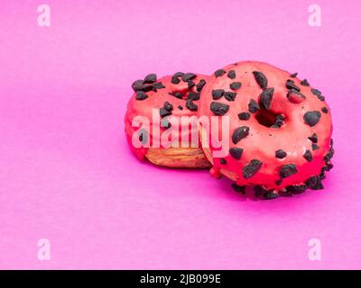 Rote Kronuts auf einem rosa Hintergrund. Hochwertige Fotos Stockfoto