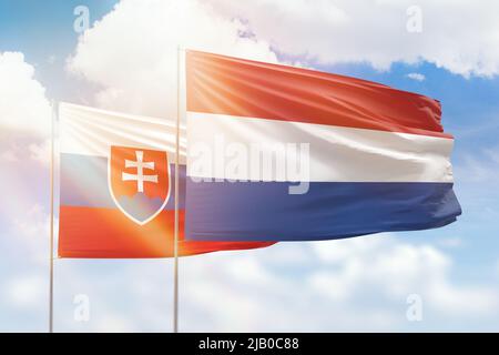 Sonniger blauer Himmel und Flaggen der niederlande und der slowakei Stockfoto