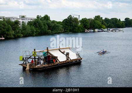 Berlin, Deutschland. 01.. Juni 2022. Das Schiff des documenta-Projekts "Citizenship" wird vom Ruder Club Tegelort über die Havel gezogen. Für das Projekt wurde die Dachkonstruktion des Berlin Center for Art and Urbanism als Floß neu gestaltet. „Citizenship“ ist mit einem Pedal- und Rudersystem sowie nachhaltigen und recycelten Antriebssystemen ausgestattet. Quelle: Fabian Sommer/dpa/Alamy Live News Stockfoto