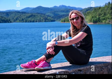 Porträt einer attraktiven blonden Frau am Seeufer Stockfoto