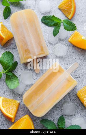 Fruchtorangeneis, Eiswürfel und Scheiben von Zitrusfrüchten. Stockfoto