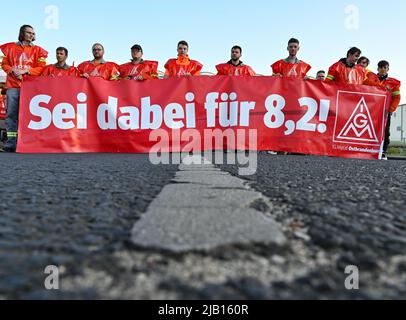 02. Juni 2022, Brandenburg, Eisenhüttenstadt: Stahlarbeiter der ArcelorMittal Eisenhüttenstadt GmbH halten während eines Warnstreiks ein Transparent mit der Aufschrift "sei 8,2 dabei!" Nach zwei ergebnislosen Verhandlungen in der Tarifverhandlungsrunde der ostdeutschen Stahlindustrie verstärkt die IG Metall den Druck auf die Arbeitgeberseite und fordert Warnstreiks. Am Morgen hatten die Mitarbeiter des Stahlwerks ArcelorMittal in Eisenhüttenstadt von 6:00 bis 8:00 Uhr ihre Arbeit eingestellt, um ihre Forderung nach einem fairen und guten Tarifergebnis zu unterstreichen. IG Metall fordert eine Erhöhung um 8,2 Prozent Stockfoto