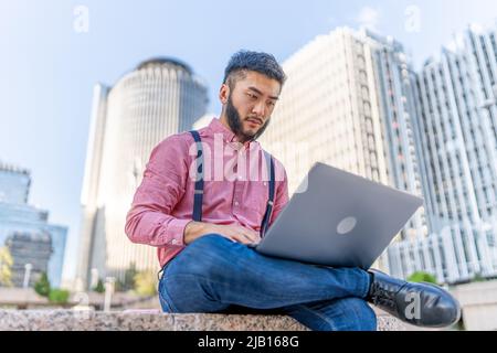 Porträt eines chinesischen Mannes, der mit einem Laptop arbeitet Stockfoto