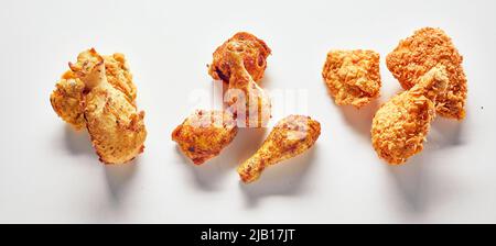 Draufsicht auf Chicken Nuggets und Beine auf weißem Hintergrund im Studio angeordnet Stockfoto