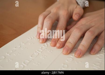 Eine Frau lernt das Braillealphabet mit einem Decoder. Stockfoto