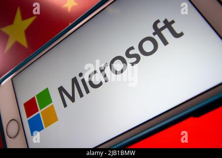 Kumamoto, JAPAN - Mär 10 2021 : Microsoft-Logo auf dem iPhone mit chinesischer Flagge im Hintergrund. Cyberangriff, IT-Technologierisiko und Konfliktkonzept Stockfoto