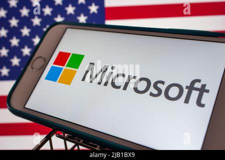 Kumamoto, JAPAN - Mär 10 2021 : ein Microsoft-Logo des US-amerikanischen Technologieunternehmens auf einem iPhone mit US-Flagge. Stockfoto