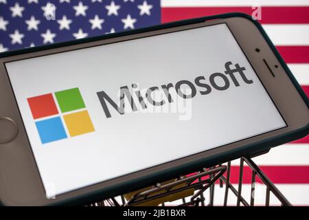 Kumamoto, JAPAN - Mär 10 2021 : ein Microsoft-Logo des US-amerikanischen Technologieunternehmens auf einem iPhone mit US-Flagge. Stockfoto