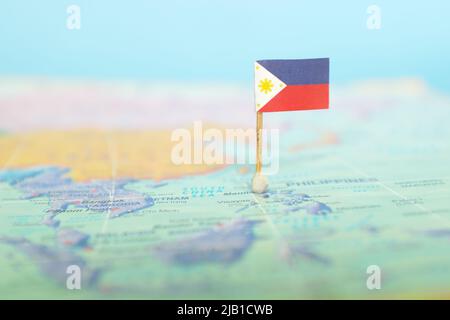 Selektiver Fokus der philippinischen Flagge auf der Weltkarte. Standort auf den Philippinen. Stockfoto