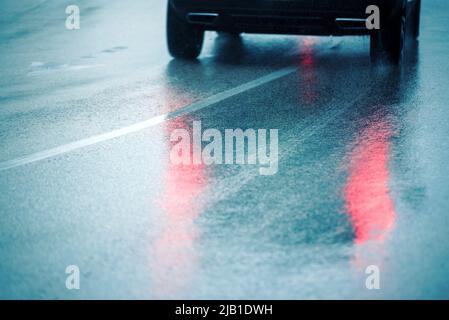 Die Spiegelung von beweglichen Autoleuchten auf nassem Asphalt Stockfoto