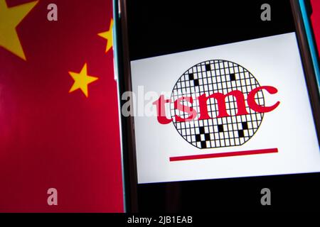 Kumamoto, JAPAN - Apr 20 2021 : das Logo der Taiwan Semiconductor Manufacturing Company, Limited (TSMC) auf dem iPhone auf chinesischer Flagge. Stockfoto