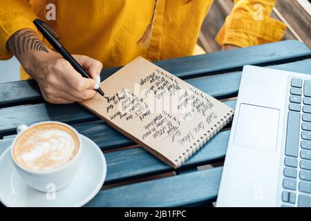 Junge Frau, die in Notizbuch-Self-Care-Ideen-Liste für den Geist, die Seele, den Körper schreibt Stockfoto