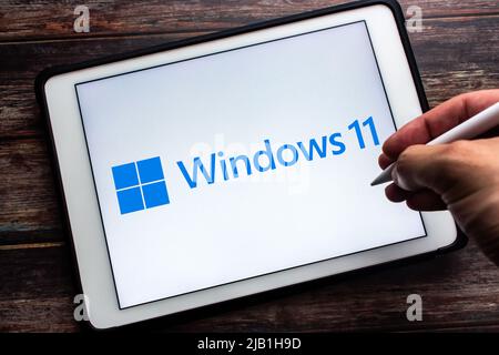 Kumamoto, JAPAN - Jun 25 2021 : Windows 11-Logo auf dem Tablet auf dem Tisch. Es handelt sich um eine Hauptversion des Windows NT-Betriebssystems von Microsoft. Der Mann hält den Stift Stockfoto