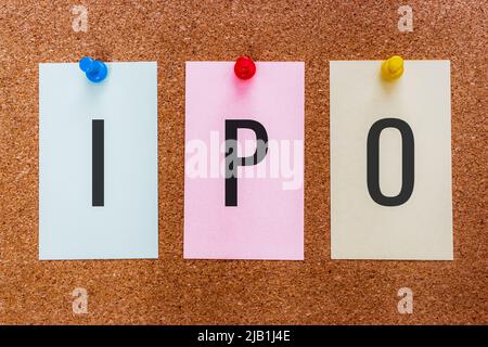 Konzeptionelle Abkürzung mit 3 Buchstaben IPO (Initial Public Offering, oder Aktieneinführung) auf mehrfarbigen Aufklebern, die an einer Korkplatte angebracht sind. Stockfoto