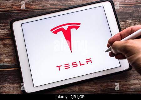 Kumamoto, JAPAN - Jul 27 2021 : das Logo des US-amerikanischen Unternehmens Tesla, Inc. Für Elektrofahrzeuge und saubere Energie auf dem Tablet. Hand mit kabellosem Stylus-Stift. Stockfoto
