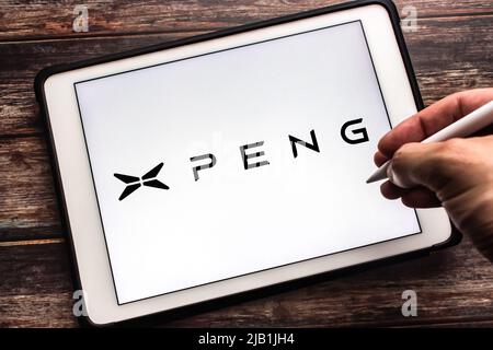 Kumamoto, JAPAN - Jul 27 2021 : Logo der chinesischen Elektrofahrzeugmarke Xpeng (Guangzhou Xiaopeng Motors, XMotors.ai) auf Tablet. Der Mann hält den Stift Stockfoto